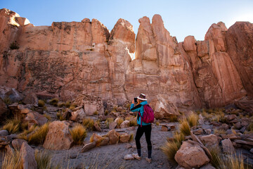 Fototapeta premium Woman taking pictures in Rocky Canyon. Bolivia
