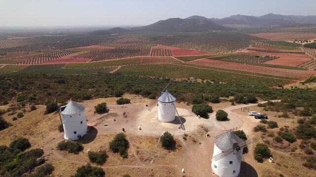 Historic windmills of Puerto Lapice standing on a hill in Don Quixote's La Mancha with vineyards in the background