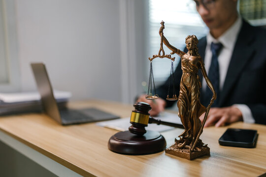Lady Justice statue and gavel on a desk, a lawyer working in a professional legal office, representing justice and law