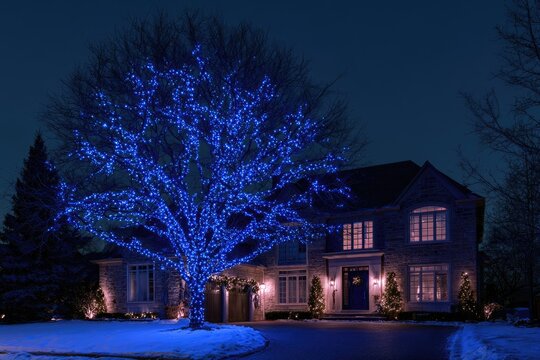 Elegant home illuminated by vibrant blue lights on a winter evening