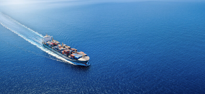 High aerial view of a container cargo ship sailing over the ocean with copy space as a banner for transport and industry
