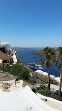 White architecture in Santorini island, Greece. Blue sea and the blue sky at sunny day. Panoramic view of the island. Travel and summer vacation concept. Vertical video
