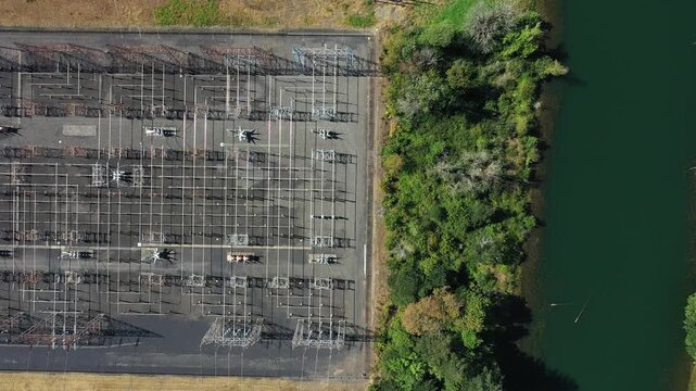4K aerial drone footage of electrical substation near Bonneville Dam, Washington, USA, showing transformers, power lines and transmission infrastructure surrounded by Columbia Gorge landscape