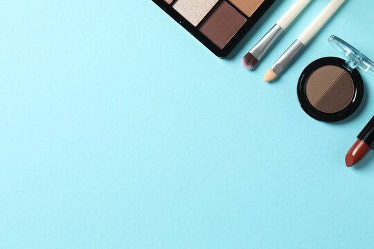 Set of decorative cosmetics on pastel blue background. Flat lay, top view.
