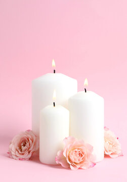Set of scented candles with pink roses on pastel background. Candles for wellness, spa and home design projects