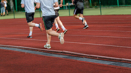 Fototapeta premium Athletes running on a red track during a race or training session
