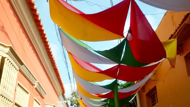 Colorful fabric shades hanging above a street in the historic Getsemani neighborhood of Cartagena, Bol&iacute;var, Colombia