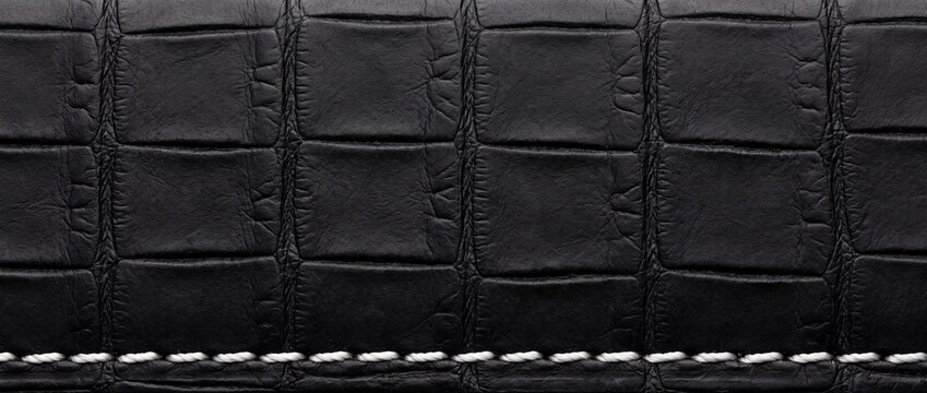 Black alligator leather watch strap texture close-up with white stitching elegant luxury material for exclusive timepieces fine craftsmanship.