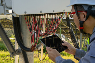 Engineer inspects electrical equipment with tablet outdoors © Zhaorui