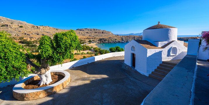 Traditional Lindos Harbor and Whitewashed Village on Rhodes Island, travel destination in Greece;
