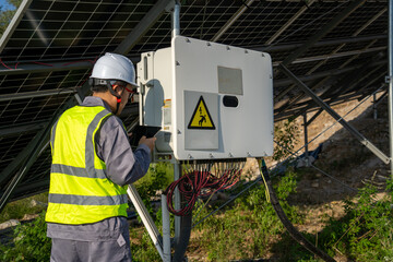 Worker inspecting solar power system equipment outdoors © Zhaorui