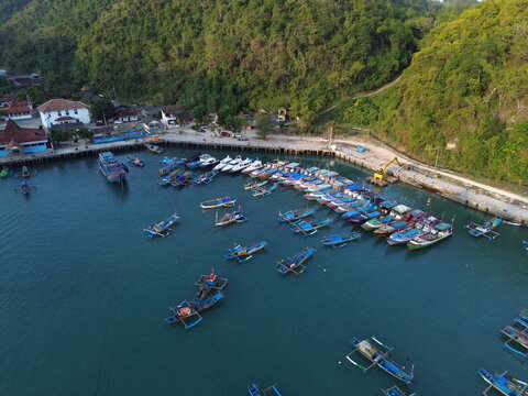 Aerial Drone View of Traditional Fishing Boats Moored at Sadeng Fishing Port During Sunset, Yogyakarta, Indonesia