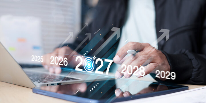 Business professional planning future growth with a digital tablet, laptop, rocket, arrows, and 2027 timeline, symbolizing business strategy, innovation, startup growth, goals,