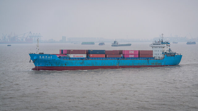 Blue container ship sails in the port of Shanghai with smog in Shanghai China