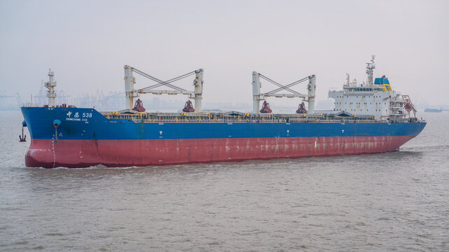 Bulk carrier vessel sails in the port of Shanghai with smog in Shanghai China