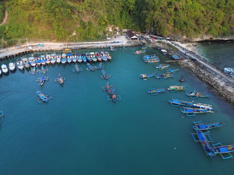 Aerial Drone View of Traditional Fishing Boats Moored at Sadeng Fishing Port During Sunset, Yogyakarta, Indonesia