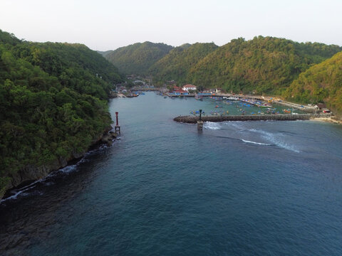 Aerial Drone View of Traditional Fishing Boats Moored at Sadeng Fishing Port During Sunset, Yogyakarta, Indonesia