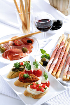 Grissini with parma ham and olives and mozzarella with tomatoes, italian starters