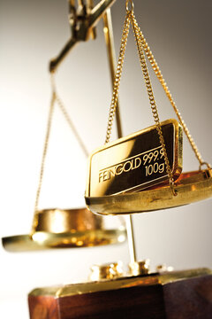 Gold bar on a a pair of scales