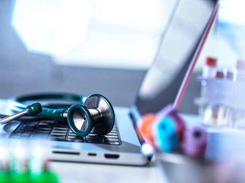 A medical laboratory features a stethoscope on a laptop keyboard