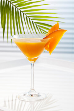 Glass of mango juice on table, close up