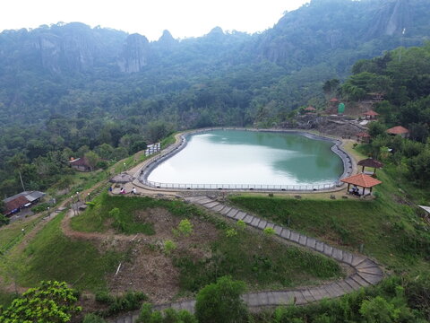 Aerial drone footage of Embung Nglanggeran, a scenic artificial reservoir located in the Ancient Nglanggeran Volcano area, Yogyakarta, Indonesia.