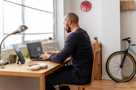 Man working with laptop at home office demonstrating focus and effort