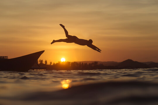 Indonesia, Lombok, man jumping into water
