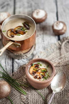 Cooking pot and bowl of mushroom cream soup with chive and fried mushroom