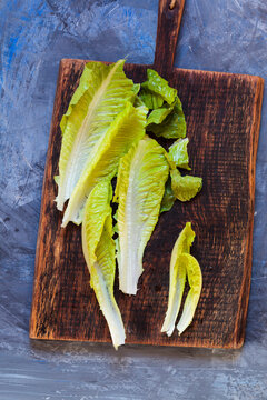 Leaves of Romaine lettuce on wooden board