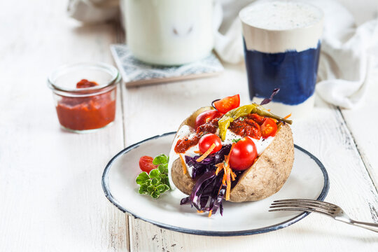 Kumpir, Turkish baked potato with raw vegetable salad, carrot, tomato, yogurt sauce, ajvar and Ayran