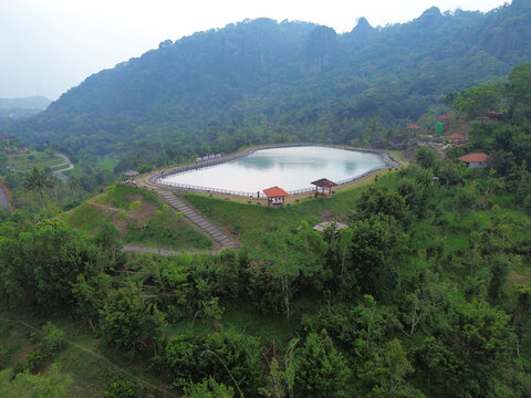 Aerial drone footage of Embung Nglanggeran, a scenic artificial reservoir located in the Ancient Nglanggeran Volcano area, Yogyakarta, Indonesia.