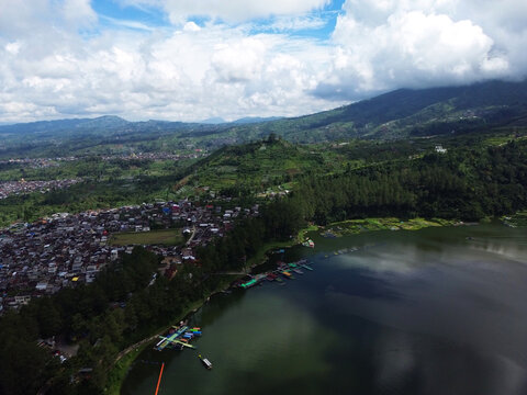 Aerial drone footage of Telaga Menjer, a beautiful volcanic lake located near the Dieng Plateau in Wonosobo, Central Java, Indonesia. Surrounded by lush green hills and spectacular mountain scenery