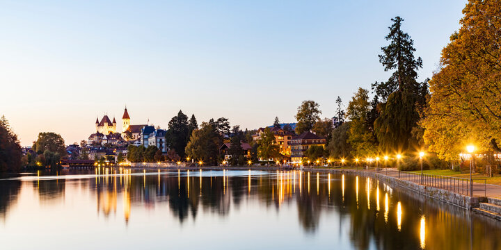 Switzerland, Canton of Bern, Thun, river Aare, old town with Aarequai, parish church and castle at dusk