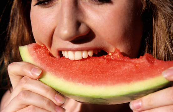 Young woman eating water melon, close-up