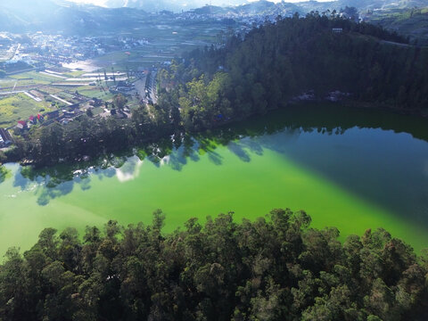 Aerial drone footage of Telaga Warna (Color Lake) on the Dieng Plateau, Central Java, Indonesia, captured during the late afternoon golden hour