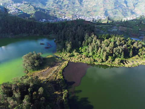 Aerial drone footage of Telaga Warna (Color Lake) on the Dieng Plateau, Central Java, Indonesia, captured during the late afternoon golden hour