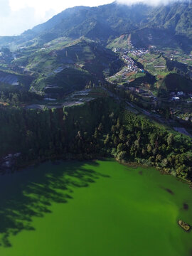 Aerial drone footage of Telaga Warna (Color Lake) on the Dieng Plateau, Central Java, Indonesia, captured during the late afternoon golden hour