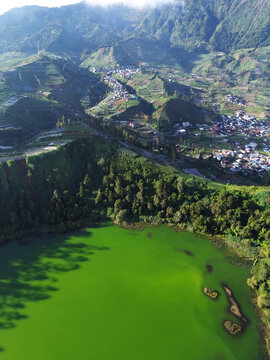 Aerial drone footage of Telaga Warna (Color Lake) on the Dieng Plateau, Central Java, Indonesia, captured during the late afternoon golden hour