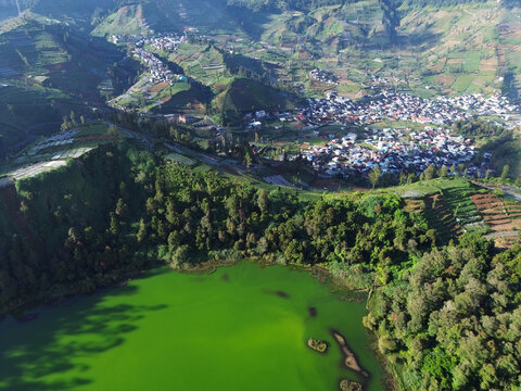 Aerial drone footage of Telaga Warna (Color Lake) on the Dieng Plateau, Central Java, Indonesia, captured during the late afternoon golden hour
