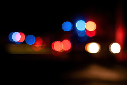 Blurred colorful lights create a vibrant, abstract nighttime scene with bokeh effects