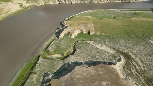 Aerial view of wide green river valley in the Himalayas near Jispa Lahaul Valley Himachal Pradesh India shot by a drone flying above

