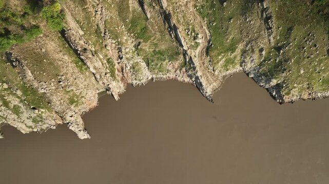 Brown river flowing through a rocky gorge in Himachal Pradesh near Jispa Lahaul Valley
