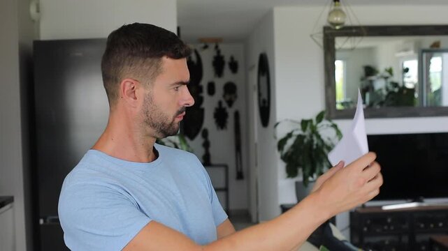 Man turning document sideways confused not understanding paper contents at all