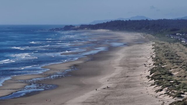 Aerial view of the sandy beach and rolling waves along the Pacific coast in Oregon City, Oregon, United States.