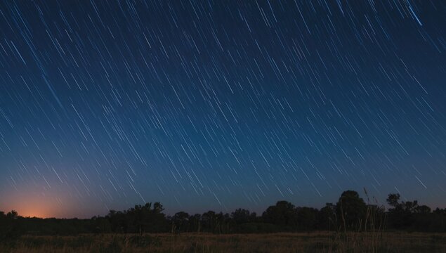Star Trails Over a Dark Field with Soft Horizon Glow