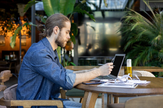 Side view of man working on laptop