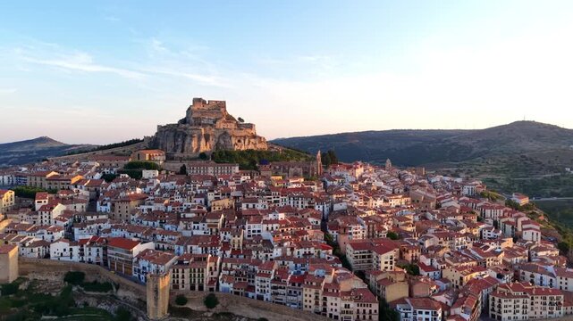 Panoramic view of Morella, a historic walled town in Castellon province, Spain, featuring its iconic hilltop castle ruins perched on rocky cliffs above terracotta rooftops