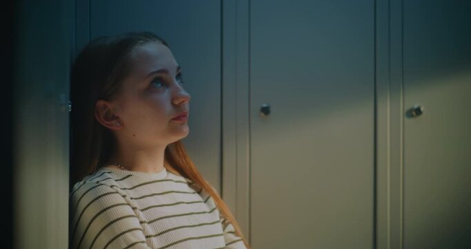 Thoughtful Teenage Girl Standing by School Lockers in Quiet Hallway, Reflecting on Personal Experiences and Everyday Challenges. Concept of Adolescence, Emotional Growth, and Authentic School Life.
