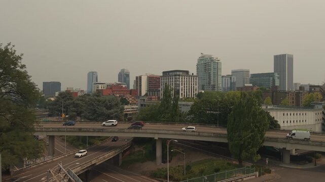 Portland, Oregon, seen by drone with city buildings and neighborhoods beneath light wildfire smoke from the Grasshopper Fire. Drone flying over 405 freeway.
